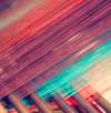 Close-up of colorful threads on a loom in a fabric mill, highlighting intricate weaving patterns